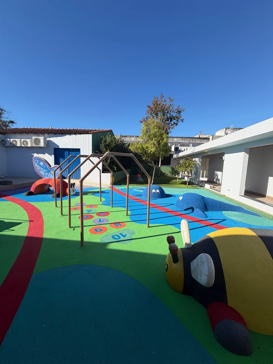 Pátio do Colégio Albert Einstein com brinquedos e piso colorido