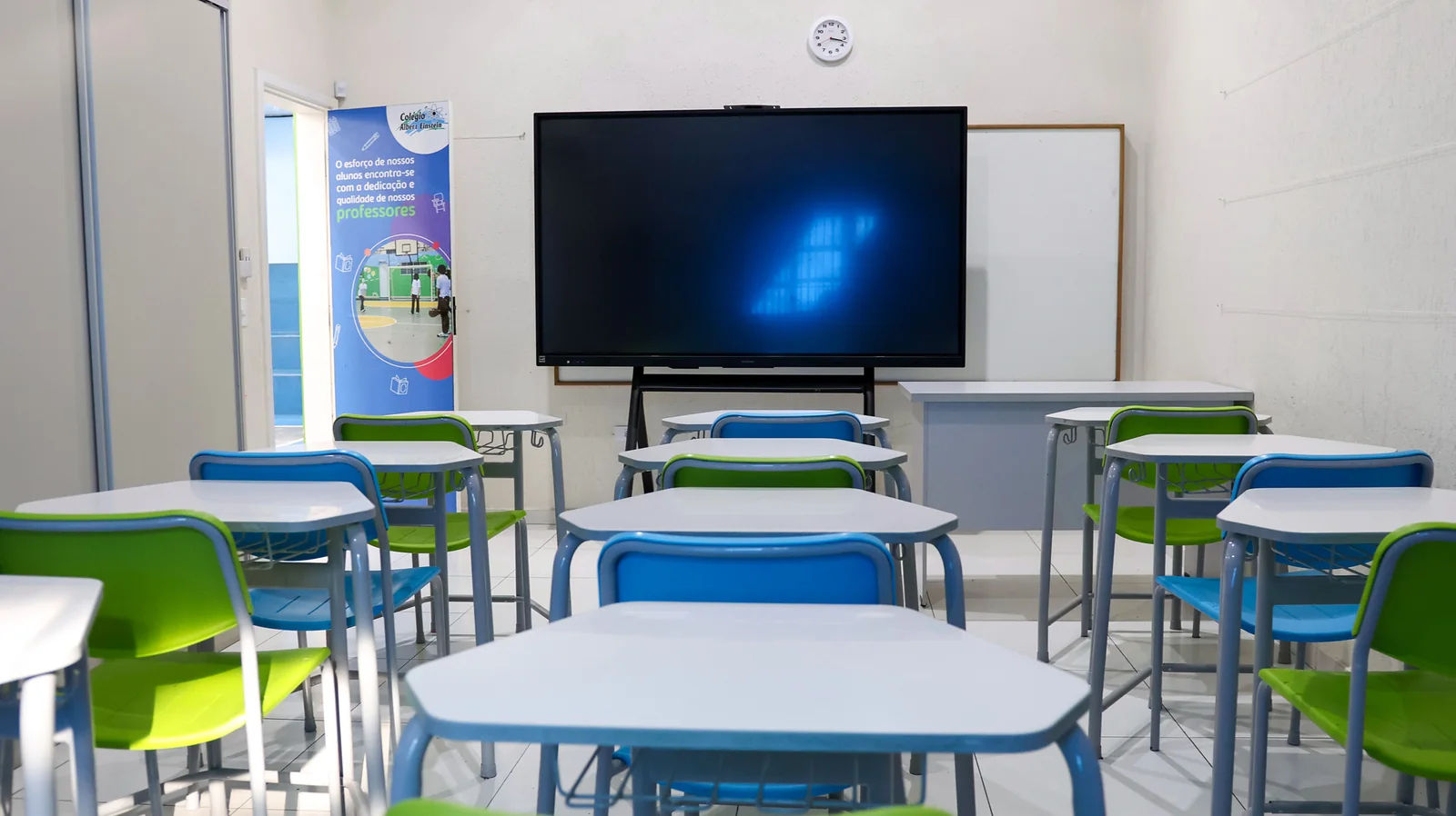 Sala de aula do Colégio Albert Einstein com carteiras e tela